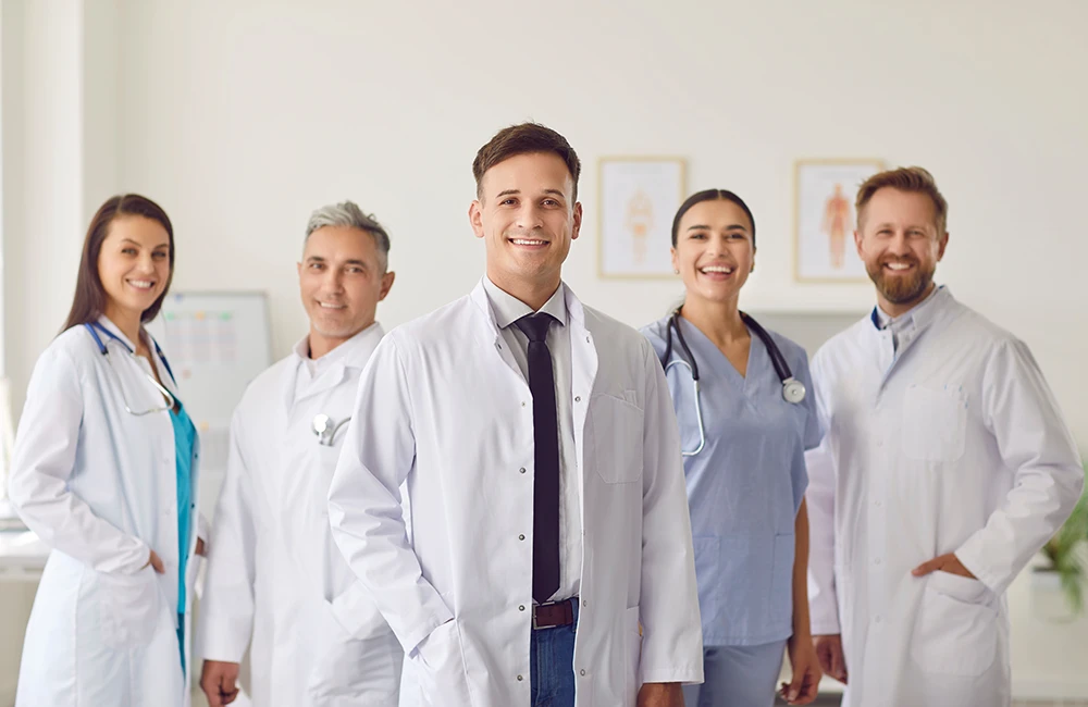 Dialysis Treatment Options - Tri-City Dialysis Portrait of a man doctor standing with a team of other doctors and nurses in the hospital